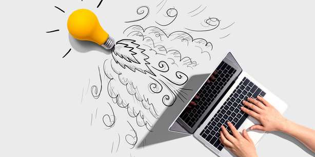 Idea light bulb flying to the sky like a rocket from a laptop computer - Flat lay 
