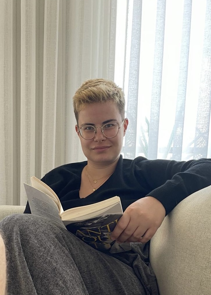 Linda Coufal reading on a sofa.